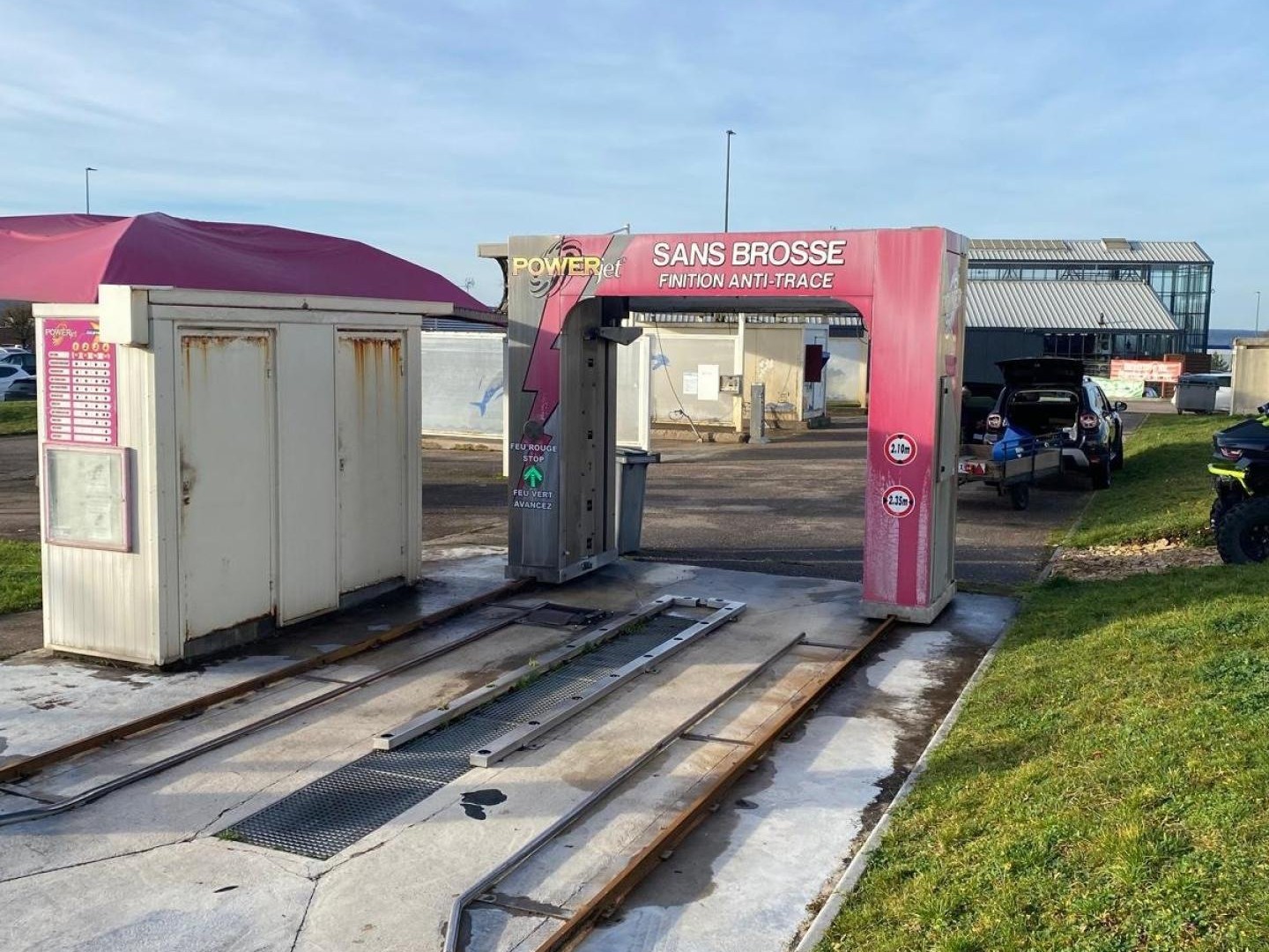 centre de lavages situé dans une zone commerciale, entre un NOZ et un Concessionnaire de motos