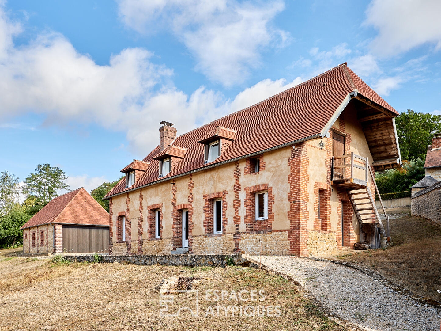 Maison en pierre rénovée et dépendances face au paysage vallonné