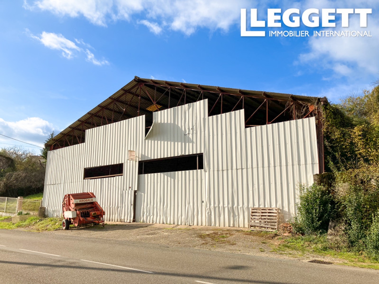 Grand garage avec jardin dans un village.