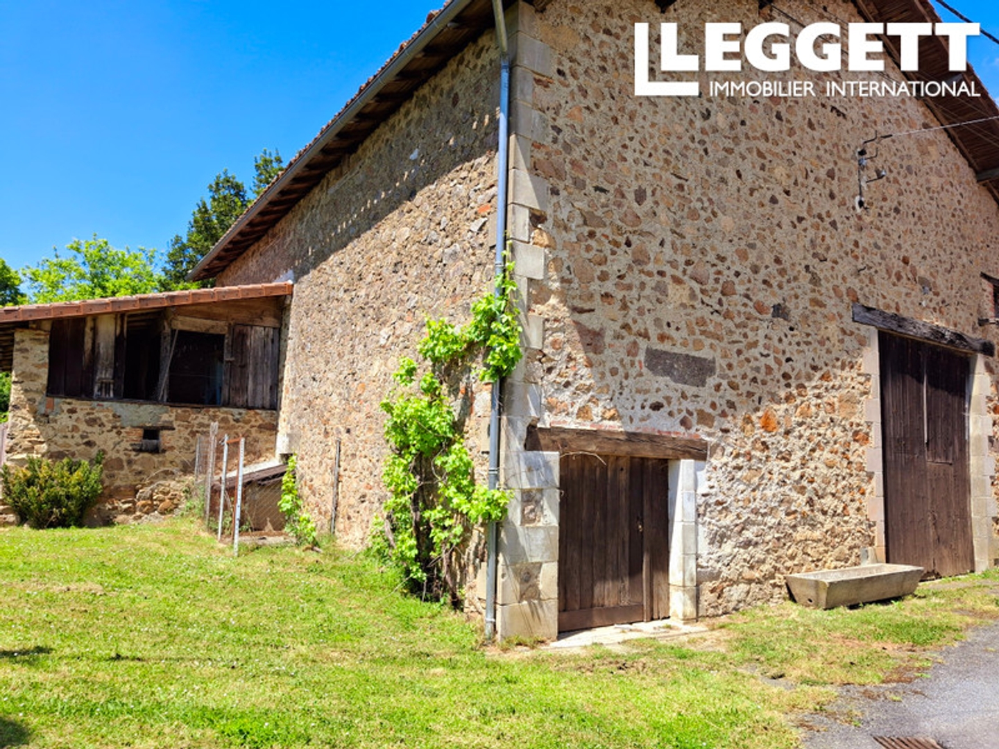 Grande grange avec jardin attenant et hangar.