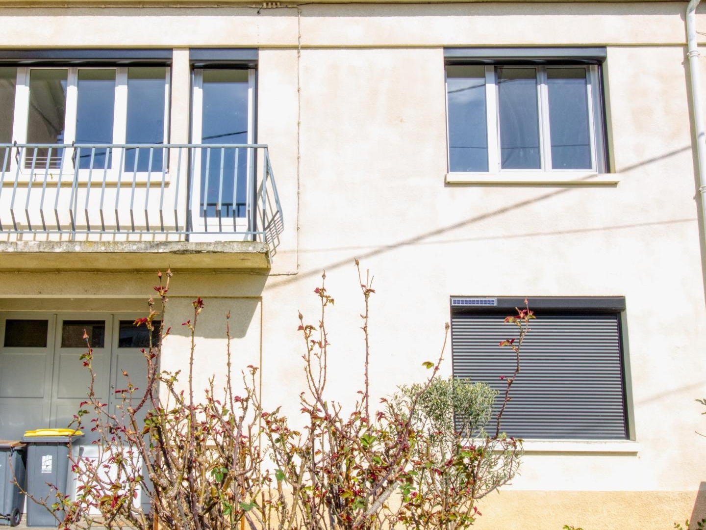 Maison de ville mitoyenne d'un côté avec garage, balcon, parking et jardinet